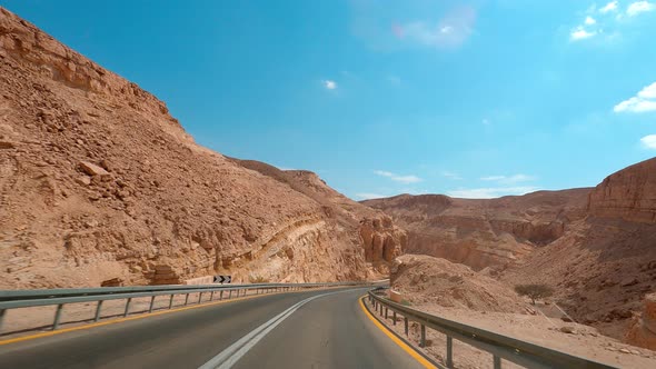 POV Driving a Car Going Down on Asphalt Eilat Road with Rocky Mountains