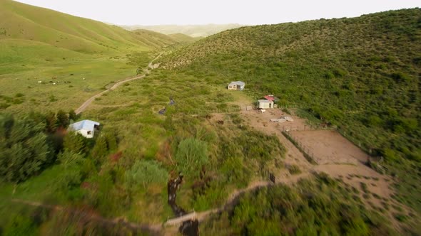 Countryside houses and narrow road near hills alt
