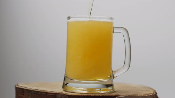 Beer Is Poured Into a Beer Glass with a Handle, a Lot of Bubbles and Foam. alt