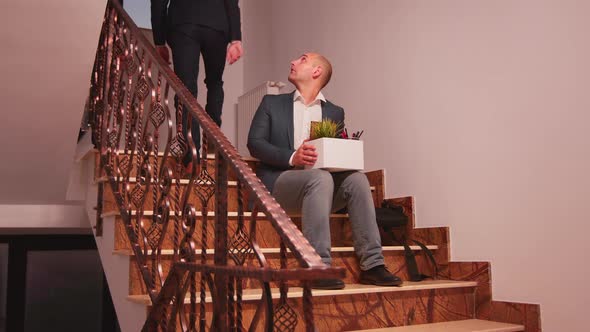 Fired Businessman Sitting on Stairs alt