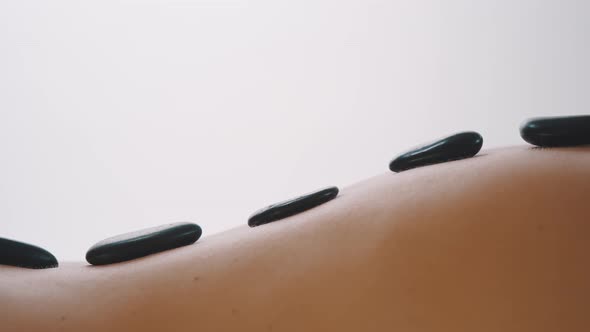 Hot Stone Massage on the Back of a Naked Woman alt