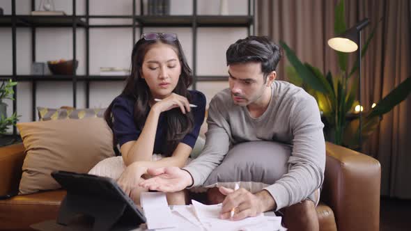 Young couple looking at invoice or bill feel worried and stressed .family financial crisis