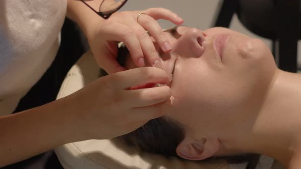 Beauty Therapist Lifts and Attaches Eye Lashes to the Silicone Pad for Lamination Procedure alt