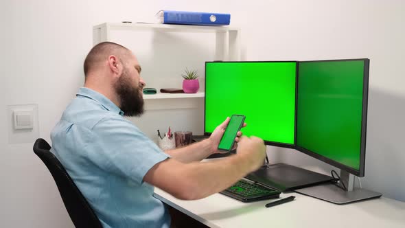 Business Man Using Mobile Phone and Computer with Green Screens Monitors. Work in Office or home alt