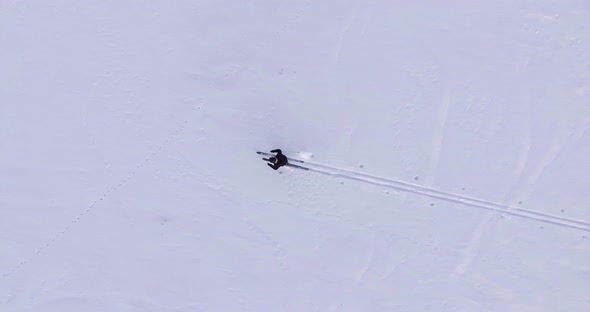 A skier walks alone in the snow