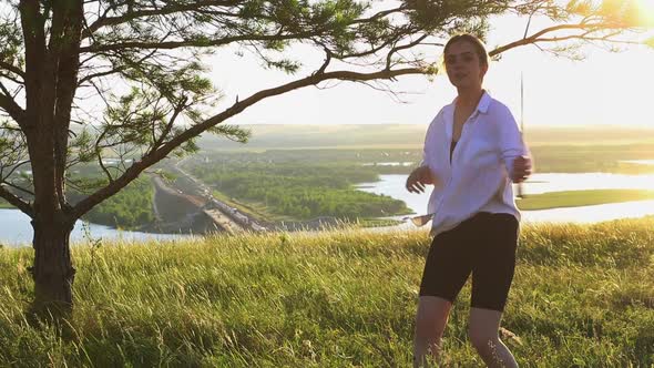 Swords Training Young Pretty Woman in White Shirt Waving with a Sword on Nature at Early Evening alt