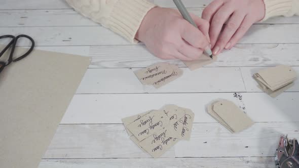 Step by step. Cutting out gift tags from brown paper with a paper punch. alt