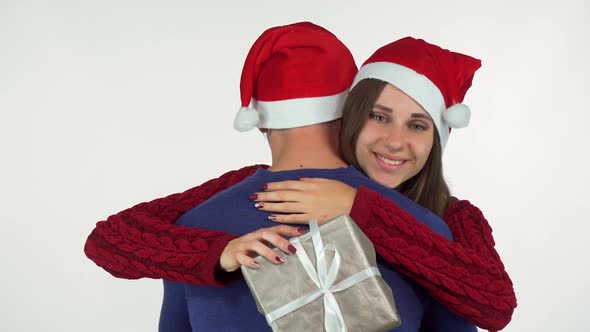 Charming Young Woman in Christmas Hat, Holding Her Present Hugging Her Man 1080p alt