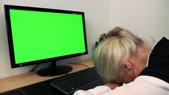 Old Caucasian Woman Sleeps at the Computer in Home - Green Screen alt