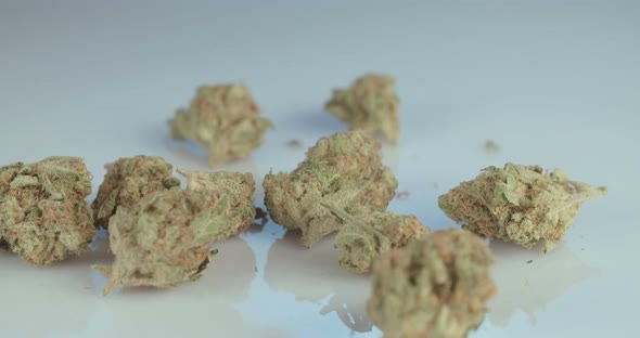 Macro shot of medicinal marijuana flowers and joint on white surface alt