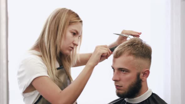 Hairdresser Doing Haircut for Customer Using Scissors in Salon alt