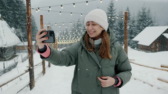 Happy Female Tourist Making Video Calls on Mobile Phone at in the Snowy Forest Woman Take Selfie in alt
