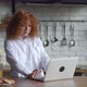 Scared Redhaired Business Woman with Curly Hair Working on Laptop Kitchen Table - VideoHive Item for Sale