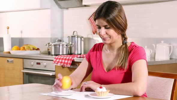 Young Woman Chooses a Cake With Cream, Not an Apple