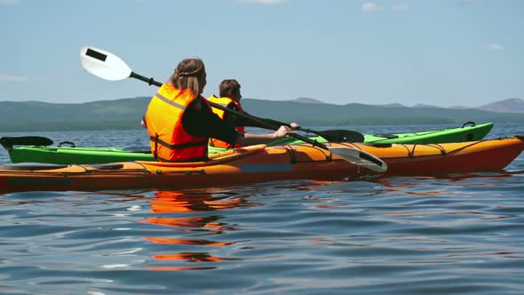 Tourists Paddling Kayaks alt