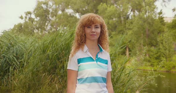 A Happy Blonde Woman at Sunset Dancing and Singing in the Park alt