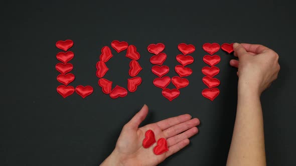 Composing a word LOVE of small red hearts. Celebration Valentine's Day