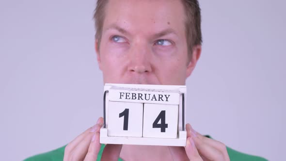 Face of Happy Young Man Thinking with Calendar Block Ready for Valentine's Day alt