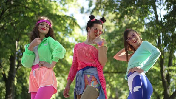 Three Flirty Women in Retro 1990s Clothes Posing in Sunny Summer Park in Slow Motion alt