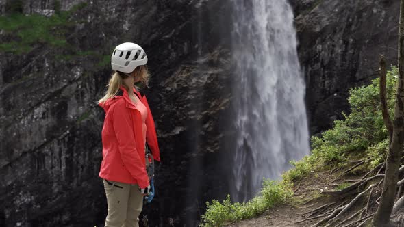 Rock Climber Watching Waterfall alt