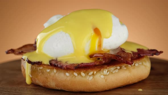 Cutting egg Benedict with runny egg yolk over toast alt