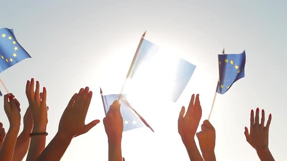 People with Raised Hands Waving Flags of the European Union. alt