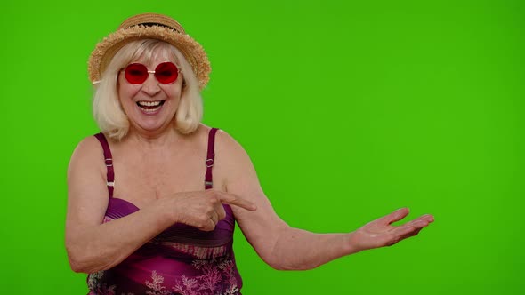 Mature Woman Traveler Holding Copy Space on Palm Pointing at Workspace Mockup for Advertisement alt