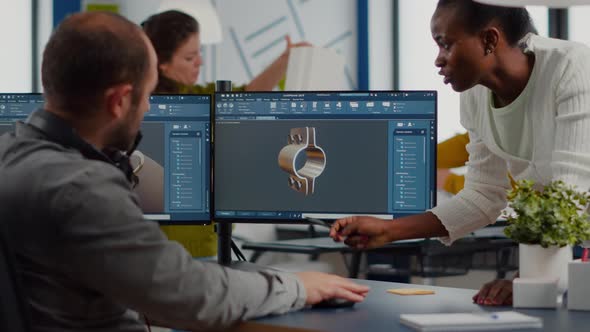 Diverse Team Discussing About Industrial Project Using Dual Monitors alt