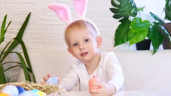 Funny happy child boy with easter eggs and bunny ears dancing and singing