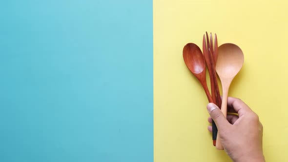 Putting Wooden Cutlery Forks on Light Yellow Background alt
