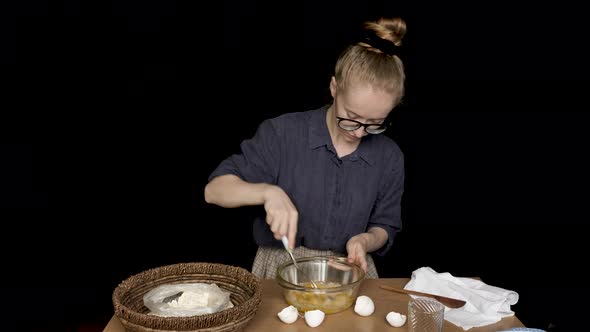Young Woman Cooking on Isolated Black Background alt