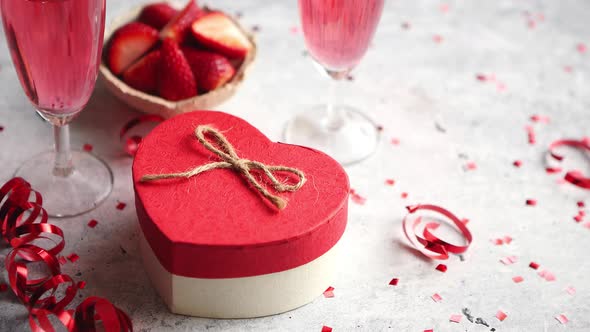 Bottle of Rose Champagne, Glasses with Fresh Strawberries and Heart Shaped Gift alt