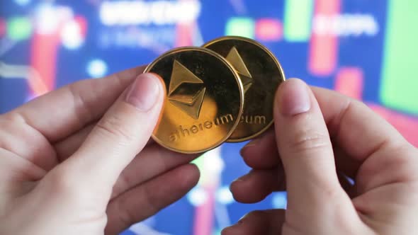 Female Hands Holding Ethereum Coins Against the Background of Stock Charts