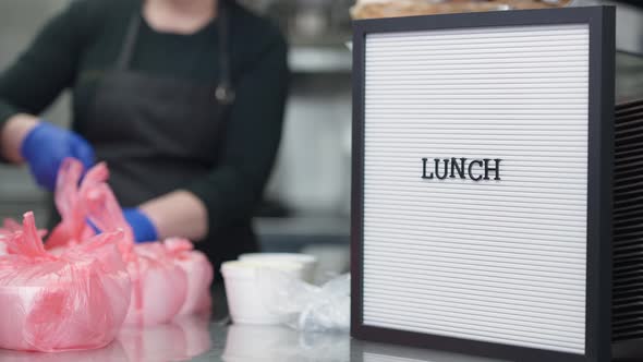 Lunch Message with Unrecognizable Blurred Caucasian Woman Packing Hot Food Containers at Background alt