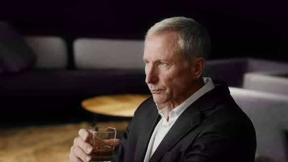 Mature Businessman Drinking Strong Alcohol Sitting In Modern Office alt
