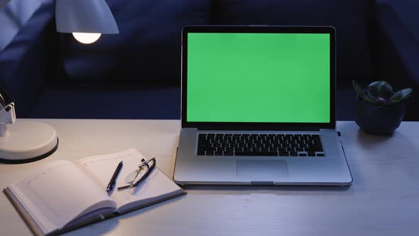 Zoom out Shot of Mock-up Green Screen Laptop Standing on the Desk in the Modern Creative Office
