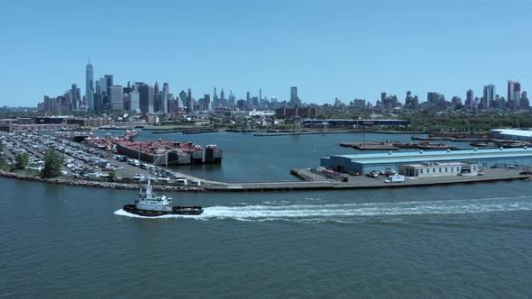 aerial footage of a single tug boat as the drone camera trucks to the right, as the tug boates left, alt
