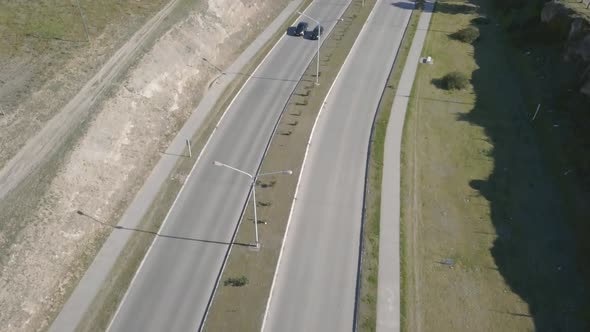 Aerial Drone shot tilting up of highway with city in the background, in Bahía Blanca, Argentina alt