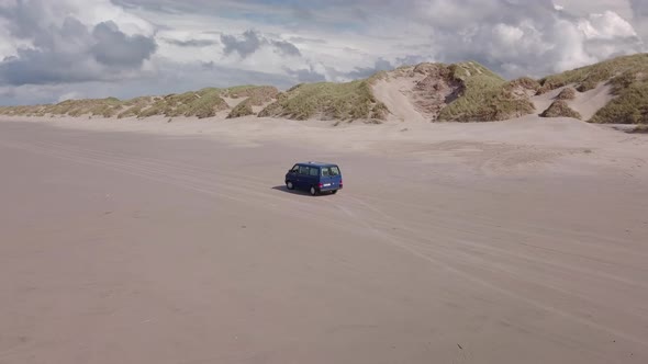 Aerial view of van driving on the beach of borsmose in Denmark alt