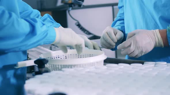 Pill Bottles are Getting Closed and Relocated By Factory Workers alt