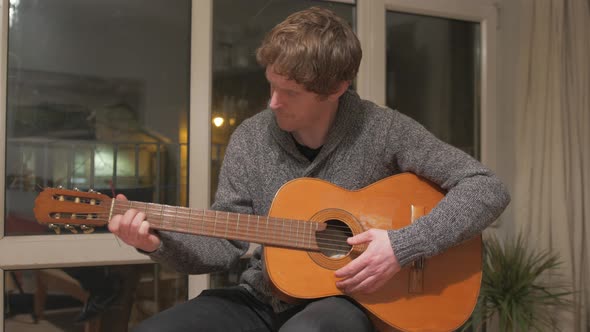 Man learning the acoustic guitar at home Medium shot alt