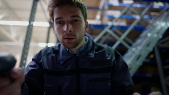Cargo POV of Young Man Using Barcode Scanner Standing in Industrial Warehouse Indoors alt