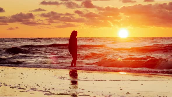 Young Girl Watching Sunset on Beach.