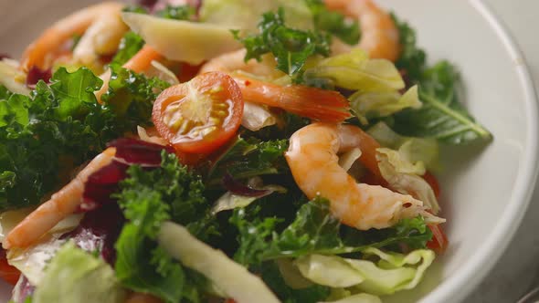 Lettuce, baked prawns, cheese and tomatoes are served with oil and herbs on top