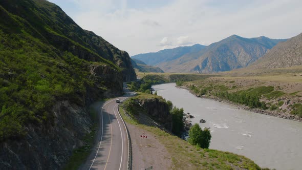 Cars on Chuya highway road between mountains and Katun river in Altai