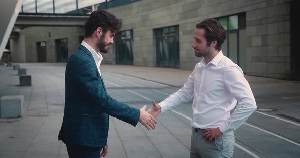 Male and His Business Partner Colleague Shaking Hands in Street Business Cooperation Meeting alt