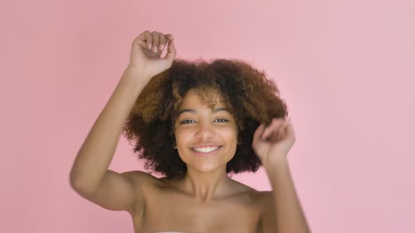 Young Pretty Darkskinned Woman Dancing Vigorously on Pink Background Closeup alt