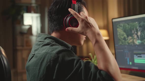 Asian Male Video Editor Start Works With Footage And Sound On His Personal Computer alt