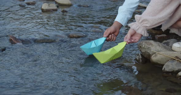 Small Children Let Paper Boats Into A Mountain River