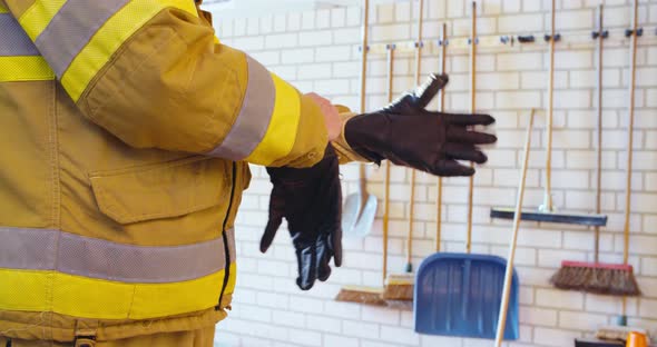 Firefighter is putting on gloves. alt